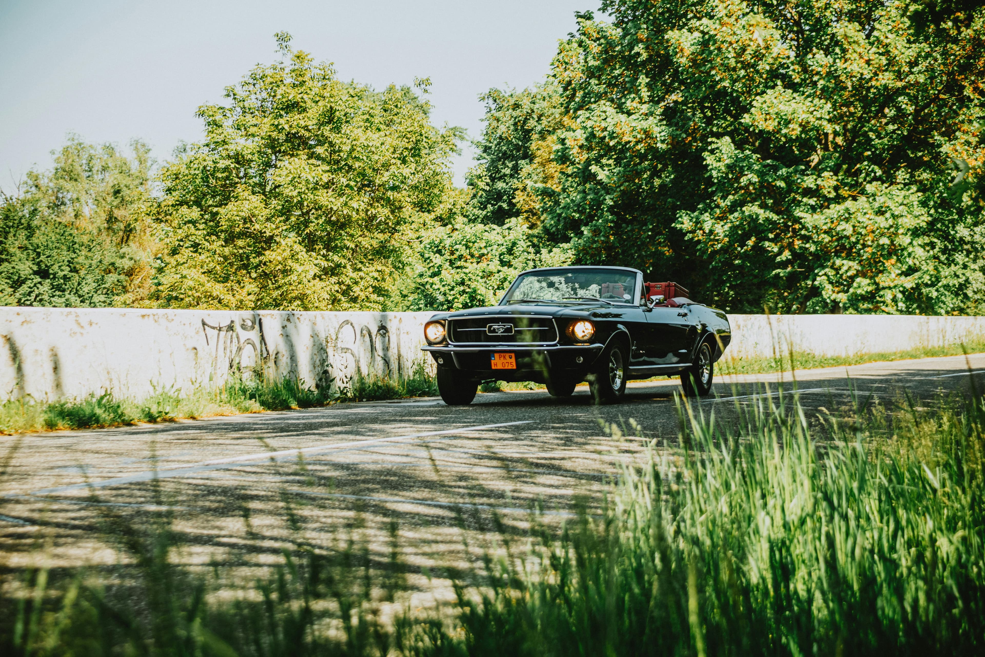 Classic car on a coastal road at sunset